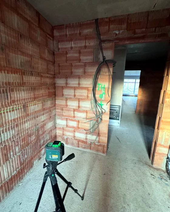 Kreuzlinienlaser auf Stativ in einem Rohbau
